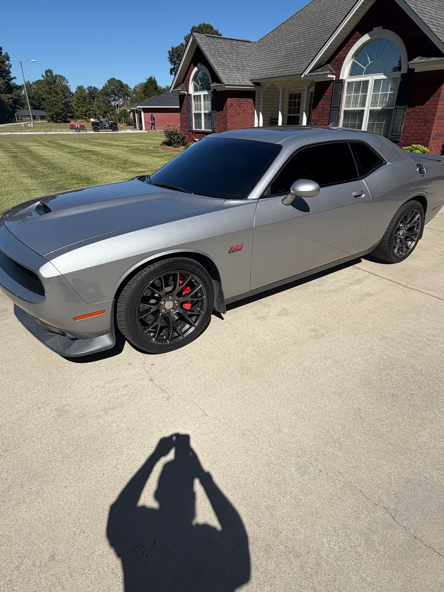 Silver Dodge Challenger with dark tinted windows parked on a driveway