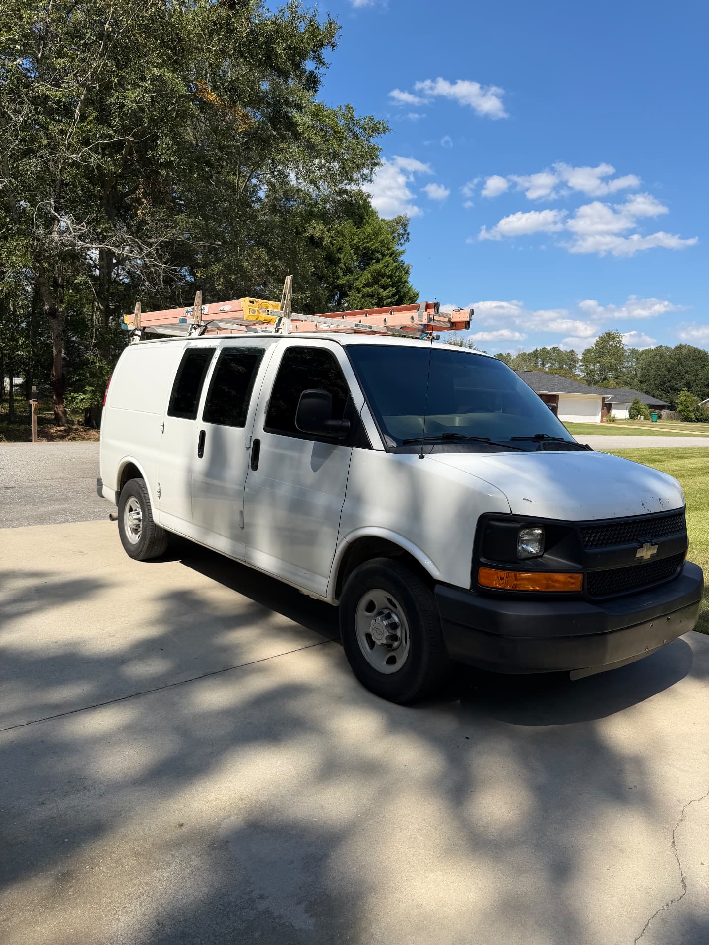 White Chevrolet work van showing dark windshield and side windows