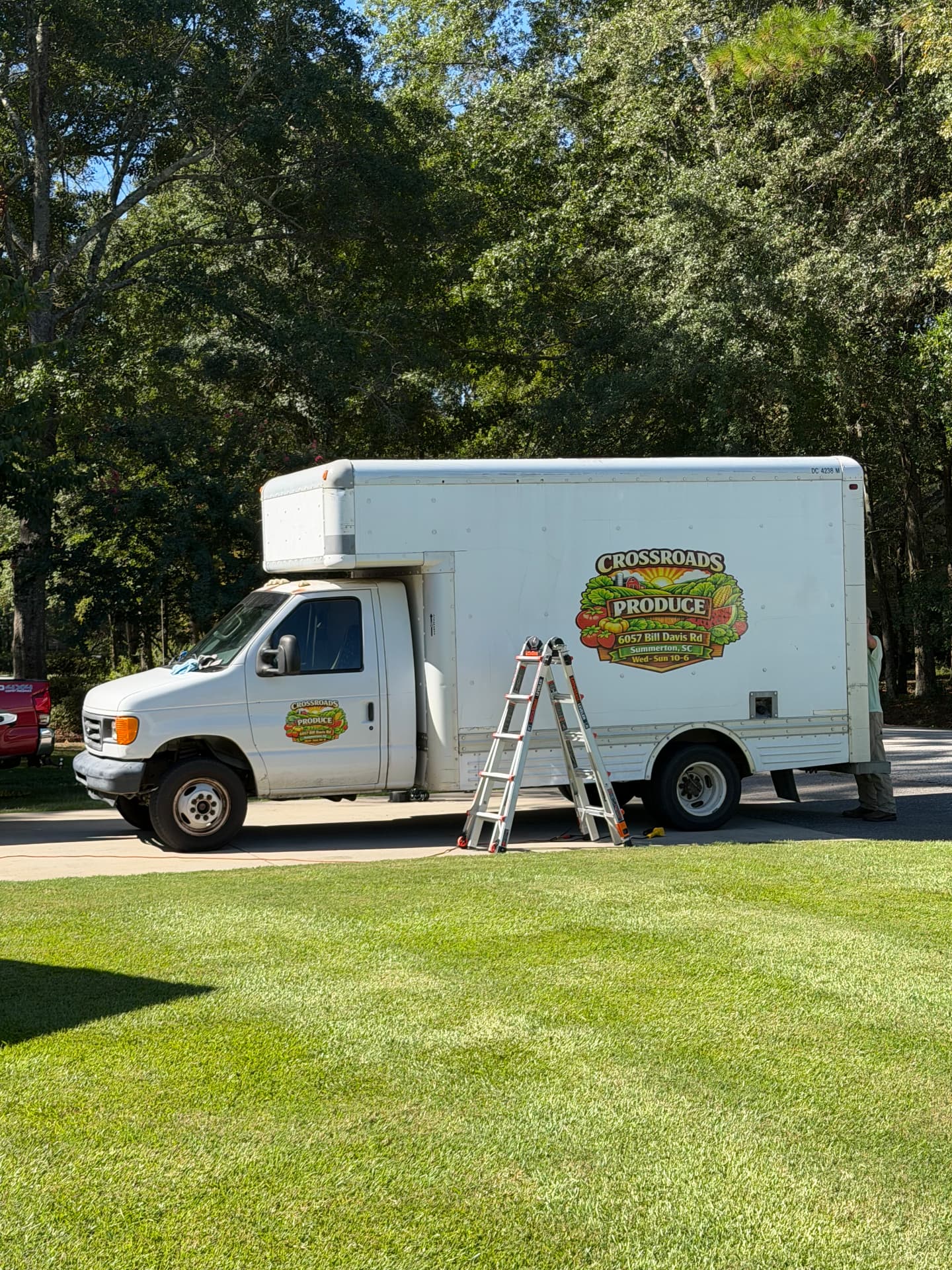Side view of a Crossroads Produce box truck showing its cab window