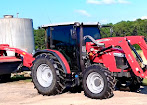 Side view of a red tractor with an enclosed tinted cab