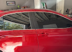 Tinted side windows on a red car inside the workshop
